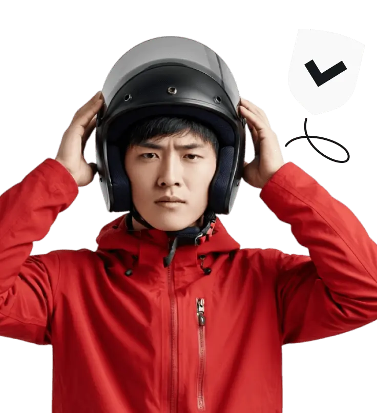 Ein Mann in einer roten Jacke setzt einen Helm auf.